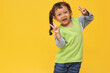 © Queenmoonlite Studio - Smile, cute of Asian little girl show v-sign over yellow background with copy space