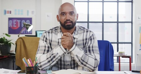 Wall Mural - portrait of biracial male designer in video call at computer in casual office, slow motion