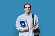 © Valerii Honcharuk - Young guy college student with backpack notebooks textbooks on blue background