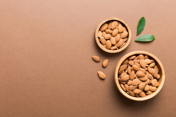 Canvas Print - Fresh healthy Almond in bowl on colored table background. Top view