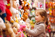 © MVProductions - Young girl buying toys in a toy store. Generative aI