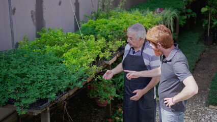 Wall Mural - Candid senior florist helping customer to buy plants at local business store