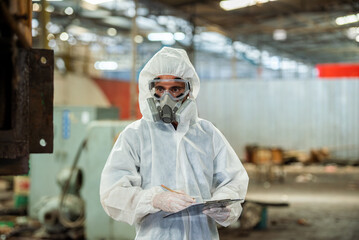 Male inspector in chemical PPE protective suit investigate chemical gas leak spill with safety face mask in area closed barricade security tape. area infected chemical leak spill cross stripe ribbon	