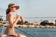 Young woman drinking wine on yacht by sea in summer vacation at sunset.