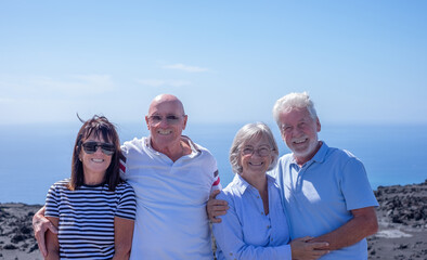 Cheerful Group of Senior Caucasian People Embracing Enjoying Sea Vacation Travel and Freedom. Horizon over water. Retirement Lifestyle Concept