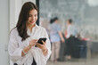 © PRIME STOCK LAB - Beautiful young millennial Asian woman using a smartphone at a cafe. Portrait of a gorgeous smiling female engrossed in her mobile phone.