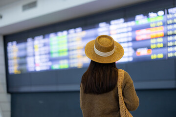 Canvas Print - Travel woman look at the flight schedule on the screen