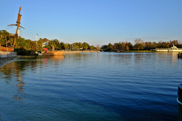 Wall Mural - Golden hour sunset over lake with buildings being reflected in the background in winter Florida 