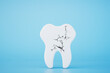 The concept of dental treatment. A tooth with cracks on a blue background. 3D render