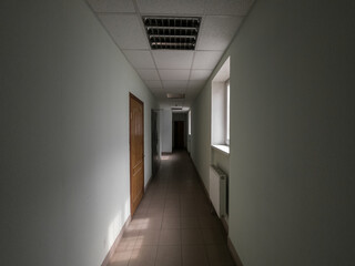 Wall Mural - empty dark office corridor lighted by windows.