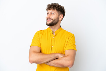 Canvas Print - Young handsome caucasian man isolated on white background looking up while smiling