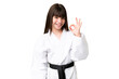 © luismolinero - Little Caucasian girl doing karate over isolated background showing ok sign with fingers