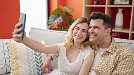 Wall Mural - Man and woman couple make selfie by smartphone sitting on sofa at home