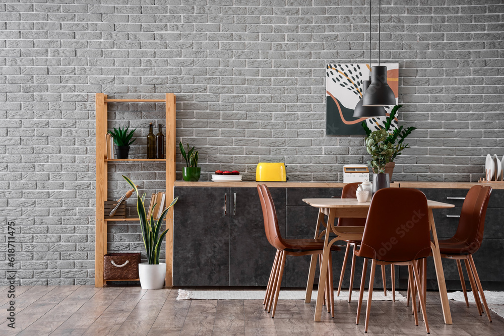 Interior of modern kitchen with dining table and grey counters