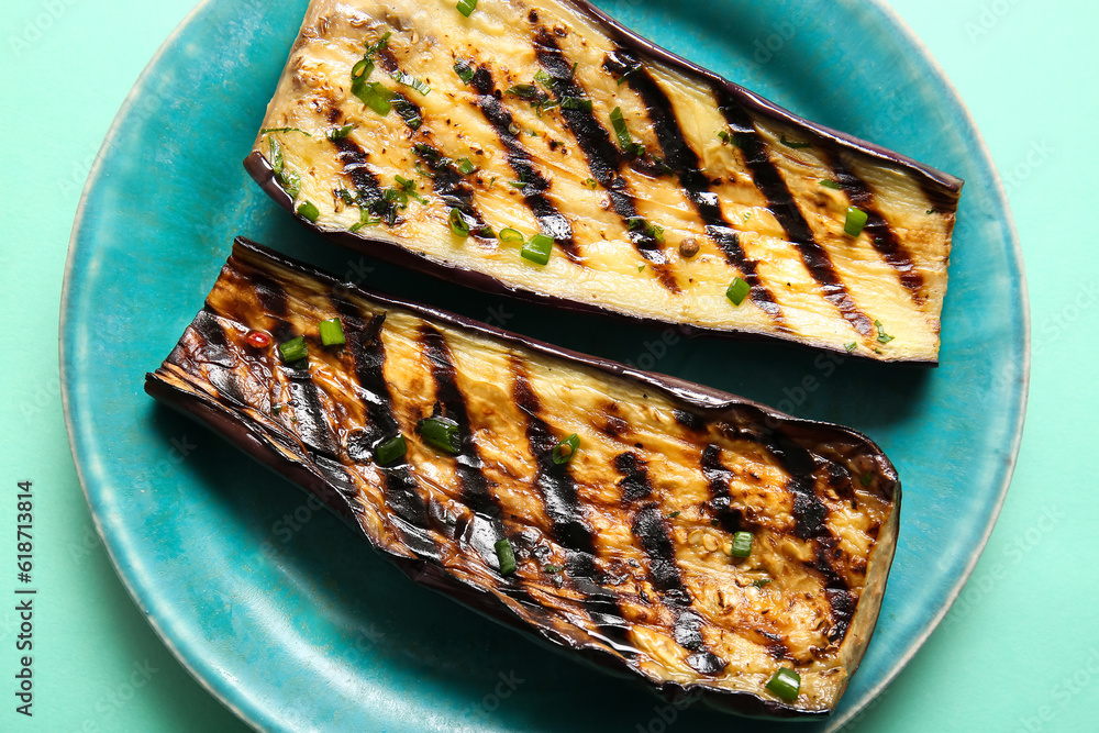 Plate with delicious grilled eggplants on turquoise background, closeup