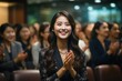 A smart Asian woman presents and receives compliments and enhancements from her teammates. People applauded with happy smiles in the conference room. business finance