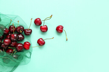 Eco bag with sweet cherries on turquoise background