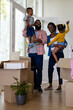 © WavebreakMediaMicro - African american parents carrying cheerful children while standing in new home