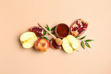 Bowl of honey, pomegranate and apples for Rosh Hashanah celebration (Jewish New Year) on pink background