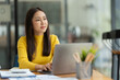 © Phimwilai - Confident Asian businesswoman using laptop computer working in office with calculator papers on table make a plan analyzing financial reports business plan investment analytical concept.