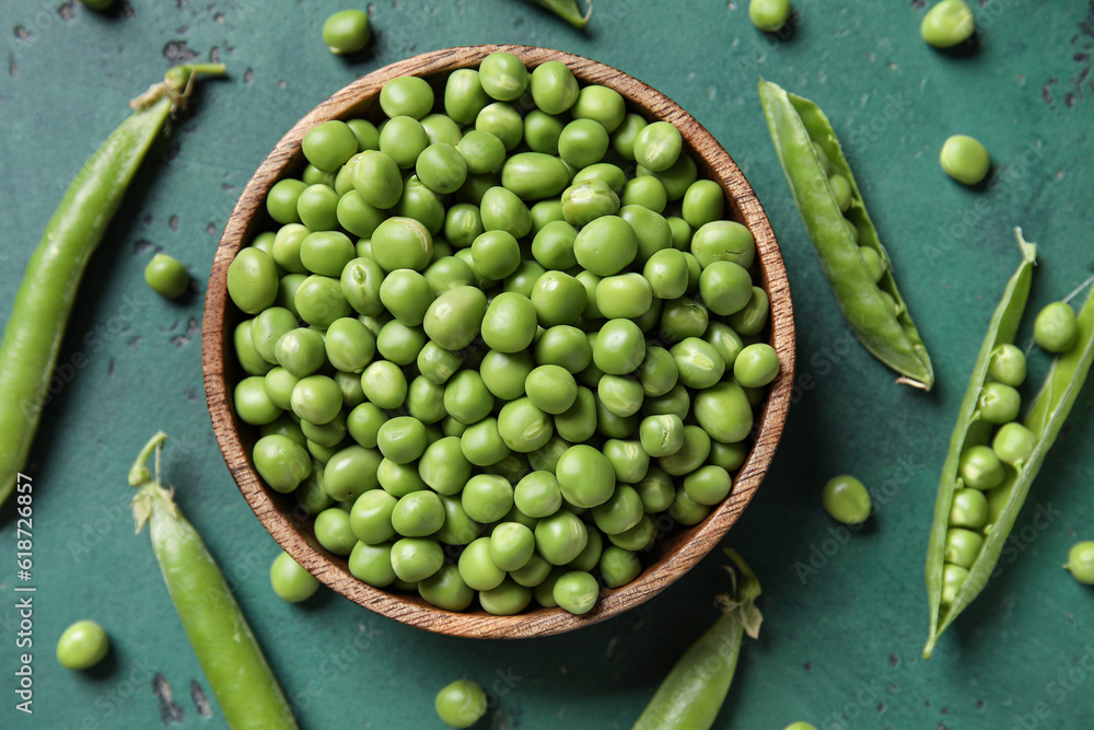 Bowl with fresh green peas on color background