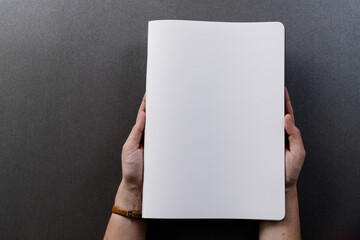 Poster - Hands of caucasian womanholding book with copy space on grey background