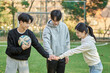 © TEAM PRE-LIGHT - Three young male and female college models walk with a ball and raise their hands in celebration after a game at a fall college futsal field in South Korea, Asia.