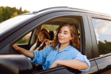 Two Young woman is resting and enjoying the trip in the car Automobile journey, traveling, lifestyle concept. Car sharing.