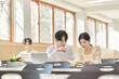 © TEAM PRE-LIGHT - In a higher education classroom in South Korea, young university students are listening to a lecture, studying, and talking. A woman and a man are in the background