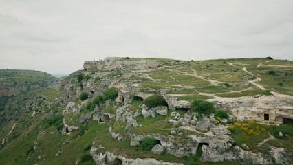 Poster - Drone shot of Murgia National Park with ruined stone buildings and caves on a hill