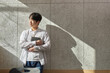 © TEAM PRE-LIGHT - Picture of a young man who is a college student standing against a wall in a lecture hall at a university in South Korea. The room is bright