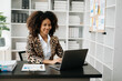 © Nuttapong punna - Business woman using tablet and laptop for doing math finance on an office desk, tax, report, accounting, statistics, and analytical research concept in office
