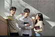 © TEAM PRE-LIGHT - Model of a young male and female college student couple leaning against the wall of a university lecture hall in a light-filled room in South Korea, Asia.