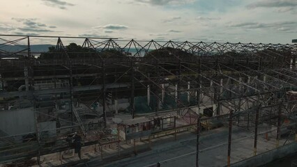 Sticker - Aerial footage showing an abandoned industrial structure with  sunset cloudy sky