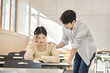 © TEAM PRE-LIGHT - Colleague, friend, motivator, young male model comforting a distressed young female college student model sitting at a desk in a university classroom in Asia Korea.
