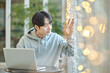 © TEAM PRE-LIGHT - Young male college student model sitting at a cafe table in Asian Korea, listening to a lecture, doing homework or working on a laptop with blurred lights in the background