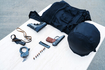 Outfit of a police officer or security guard. Bulletproof vest and firearms are on the table. Preparing for the entry into duty of an employee of the special services. Close-up. No people