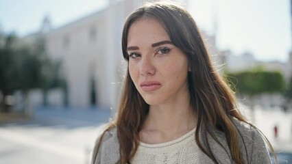 Poster - Young hispanic woman standing with serious expression looking at the camera at street