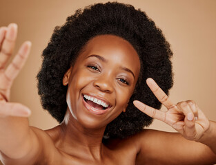 Wall Mural - Face, black woman and selfie, peace sign and beauty in studio isolated on a brown background. Portrait, v hand and excited African model taking profile picture with natural cosmetics for skincare.