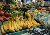 Fototapeta Kuchnia - Stragan na placu targowym z owocami i warzywami. Banany, borówki, papryka, sałata.