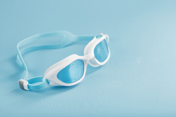 swimming goggles in a white frame with on a blue background