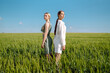 © maxbelchenko - Two stylish women posing in a green field. Beautiful girlfriends in stylish clothes walk along the green field. Fashion, style concept. Summer landscape.