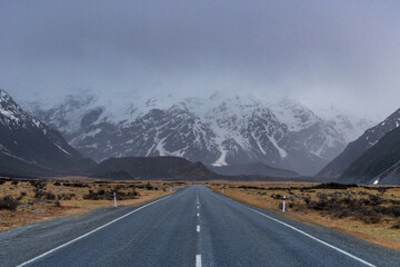 Scenic view along the Mount Cook Road alongside with snow capped Southern Alps basking in the late winter evening light. Best road trip route in New Zealand South Island with majestic Mount Cook. 