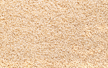 Wall Mural - Hulled white sesame seeds, surface, from above. Sesamum indicum, also called benne. Common ingredient in cuisines around the world, with nutty flavor and one of the highest oil content of any seed.