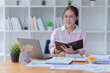 © Tj - Sharing good business news. Attractive young businesswoman talking on the mobile phone and smiling while sitting at her working place in office.