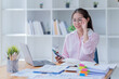 © Tj - Image of smiling beautiful woman writing down notes while sitting at table in office