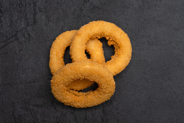 Wall Mural - Fried onion rings on black  background