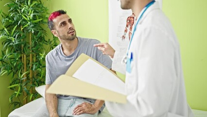 Canvas Print - Two men doctor and patient having medical consultation shake hands at clinic