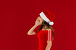 Photo of adorable positive lady wear red dress and Santa hat screaming announcement empty space isolated red color background