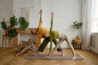 Young man and woman couple practicing yoga together standing in triangle pose
